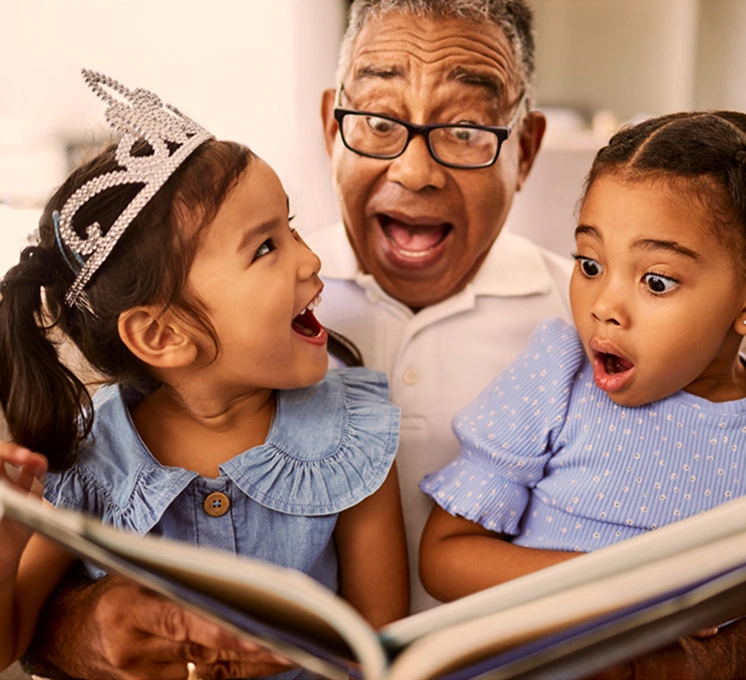 Grandfather reading a book to his children