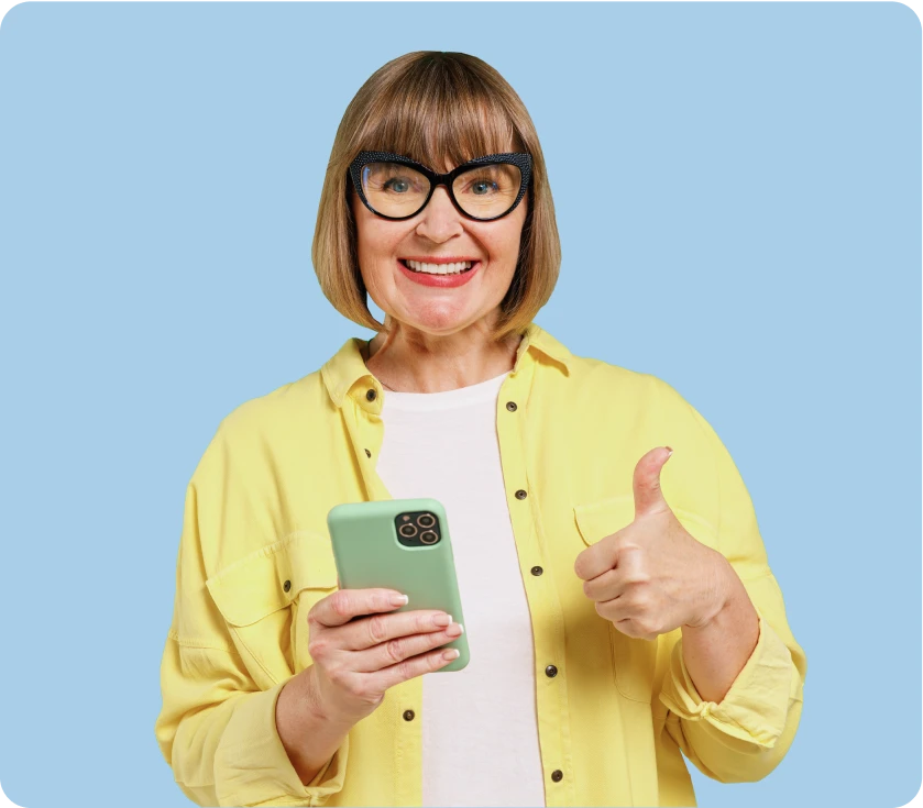 women smiling holding a phone and giving a thumbs up